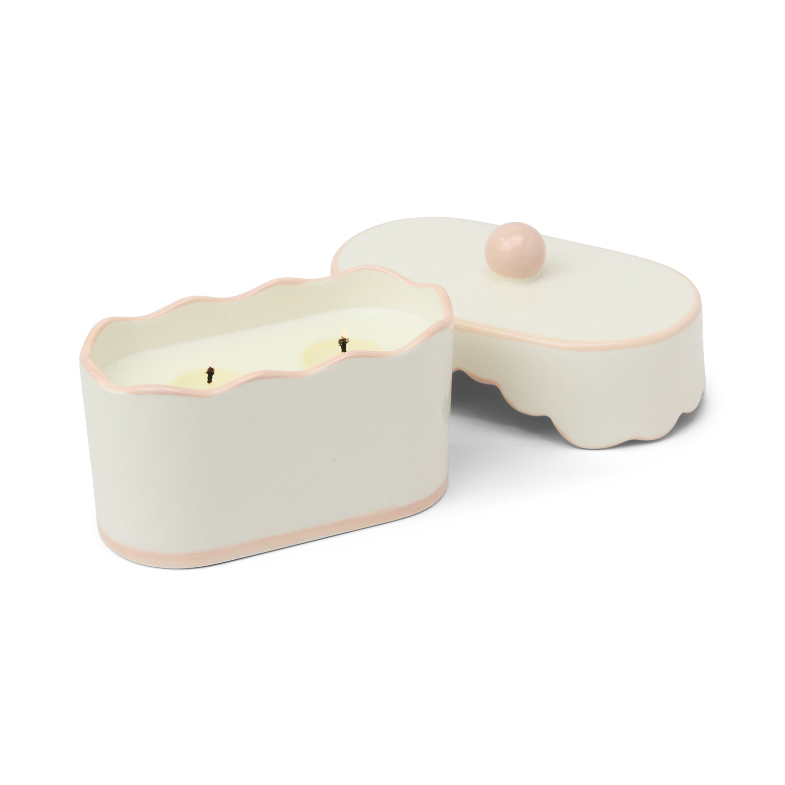 Candle in a decorative box with a pink and green pattern on a white background