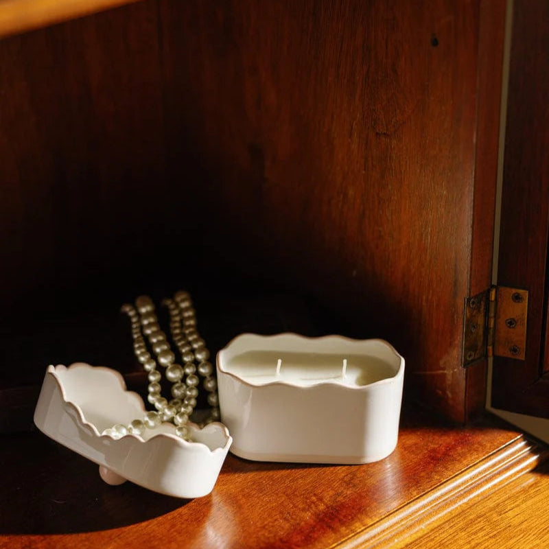 Two white ceramic containers on a wooden surface with a dark background
