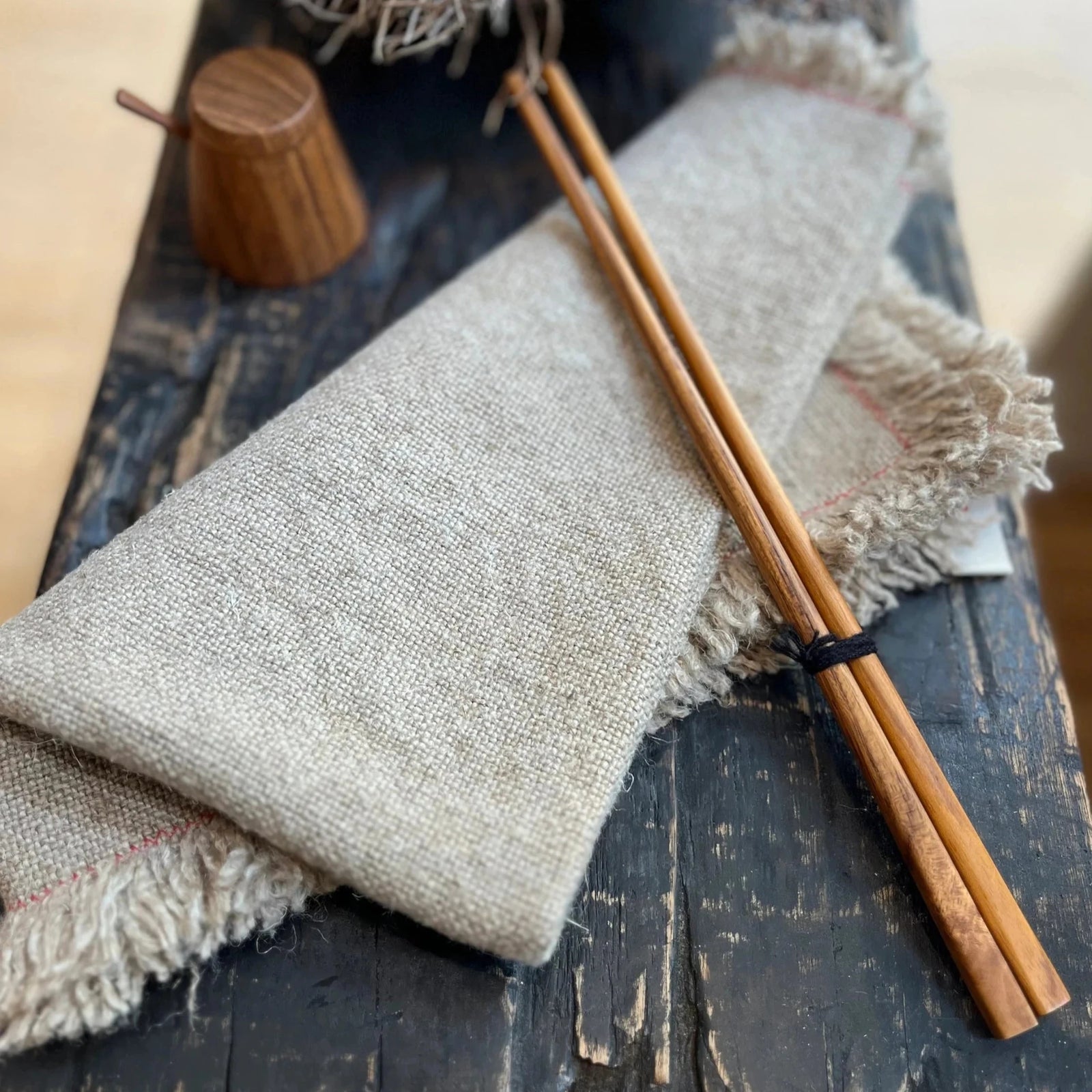 Wooden chopsticks on a textured fabric surface with a rustic background