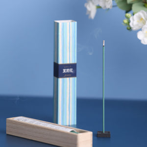 Incense stick with packaging and a wooden holder on a blue background