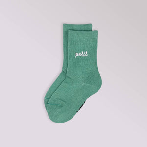 Green sock with 'petit' text on a light gray background