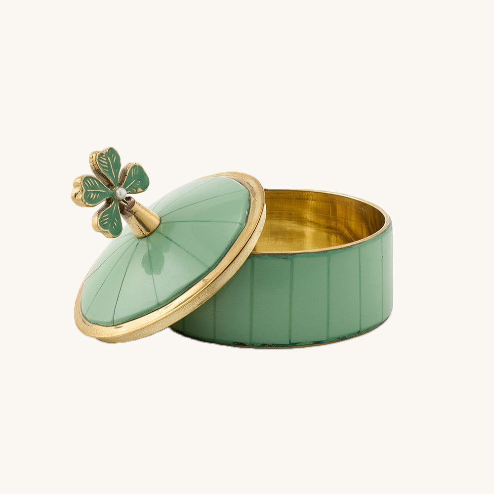 Green jewelry box with gold accents and a decorative clover on a white background