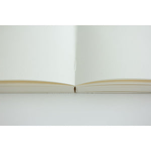 Close-up of a white book with a gold binding on a white background