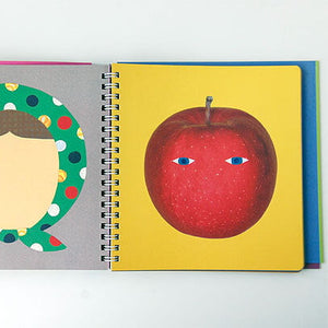 Spiral-bound book with illustrations of a face and an apple on a white background
