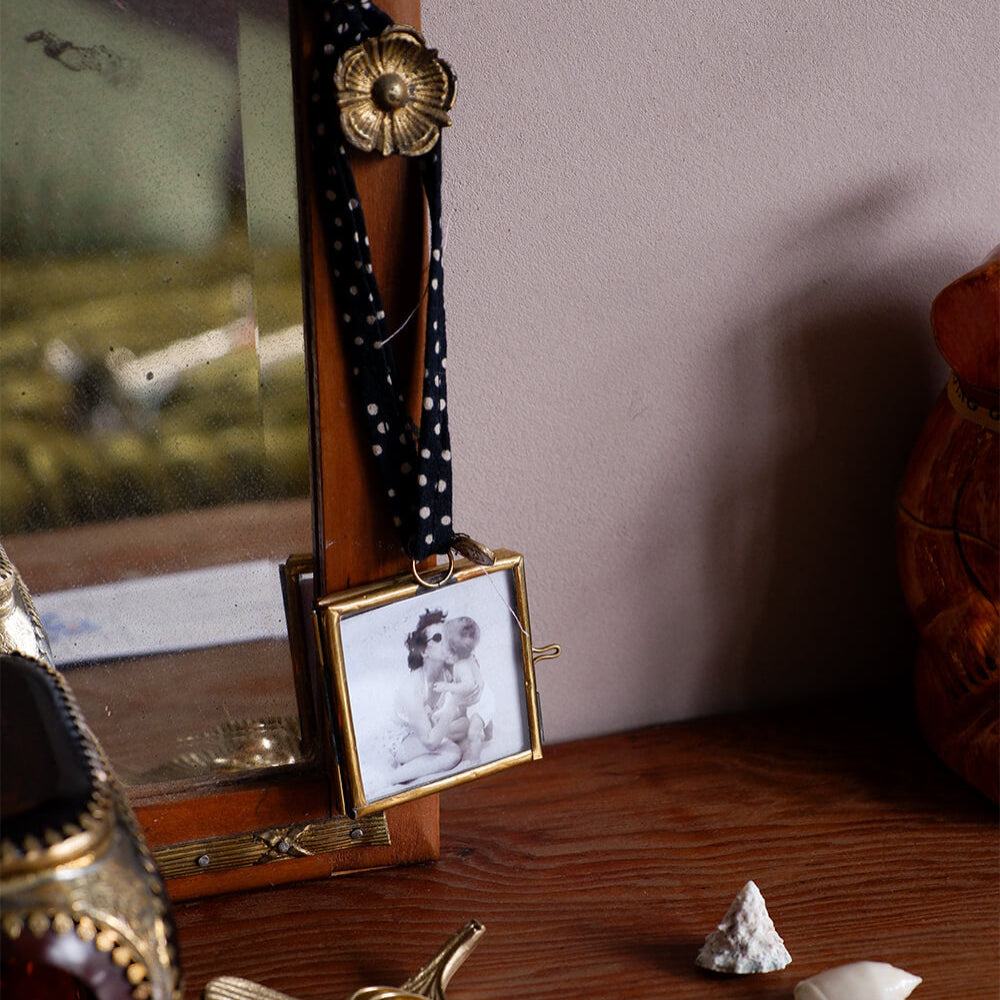 Small photo frame with a dog picture on a wooden surface with decorative items.