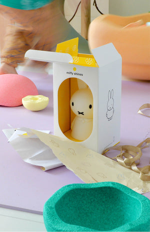 Miffy plush toy in a packaging box on a colorful background