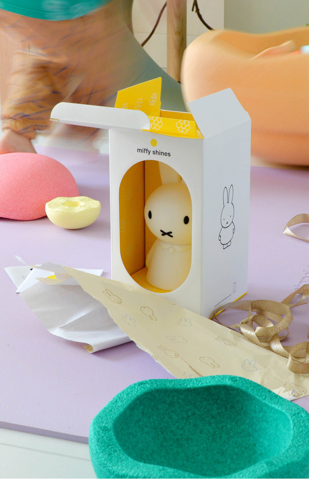 Miffy plush toy in a packaging box on a colorful background