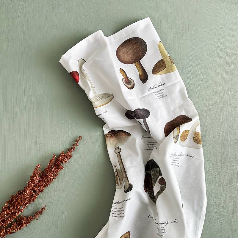 Tea towel with mushroom illustrations on a light green background