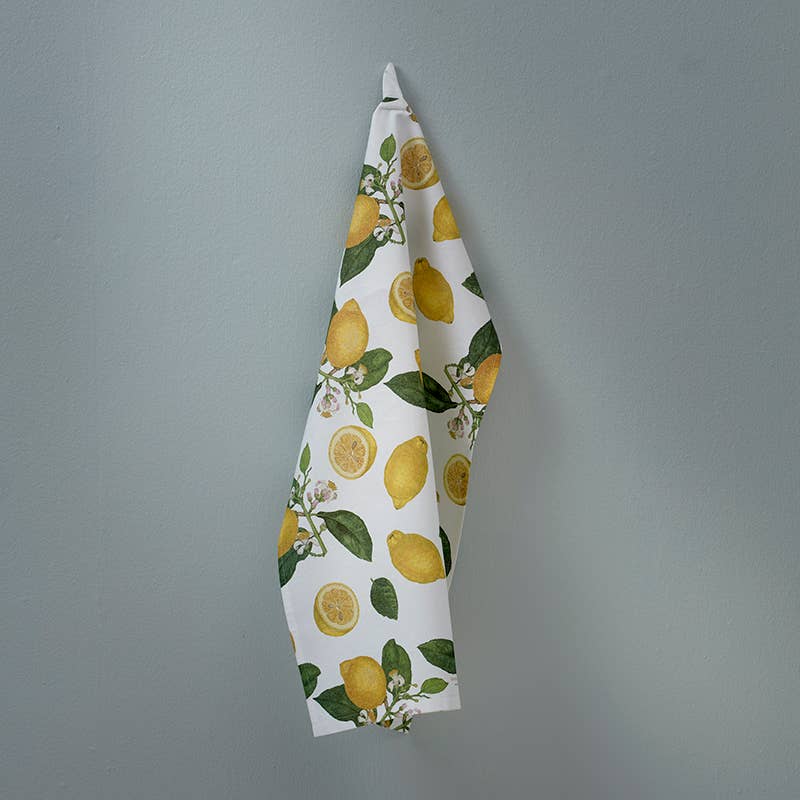 Towel with lemon pattern hanging on a gray wall