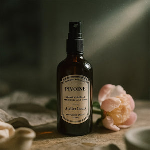 Bottle of Atelier Louis Pivoine crème végétale with a pink flower in the background