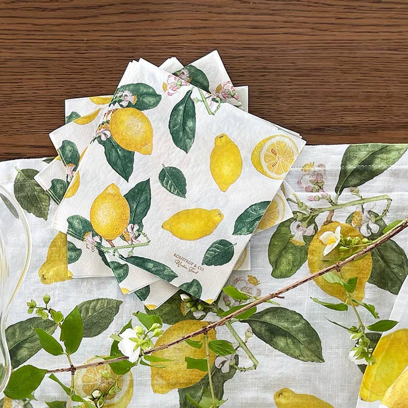 Set of paper napkins with lemon and leaf pattern on a wooden surface