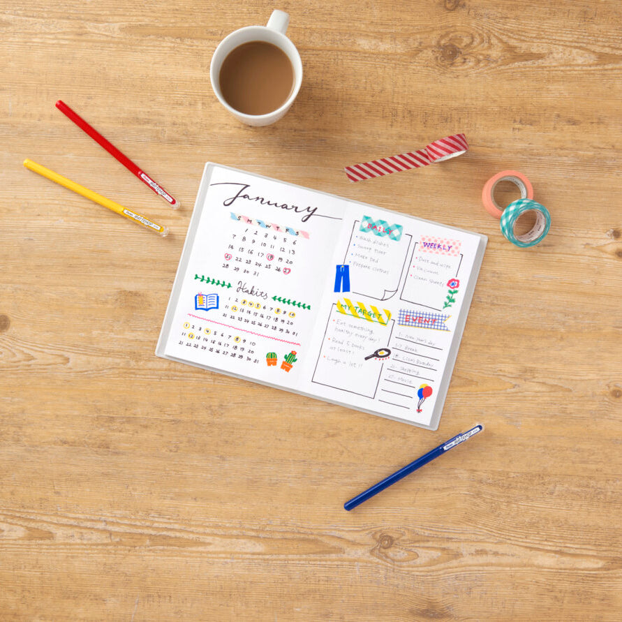 Calendar for January on a wooden surface with stationery items