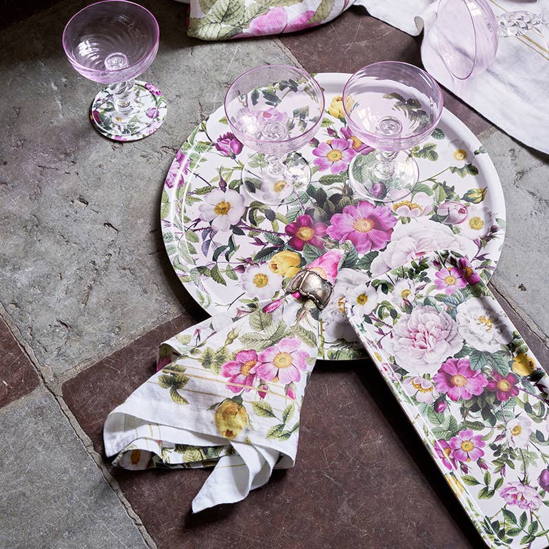 Floral table setting with plates, glasses, and napkins on a stone surface