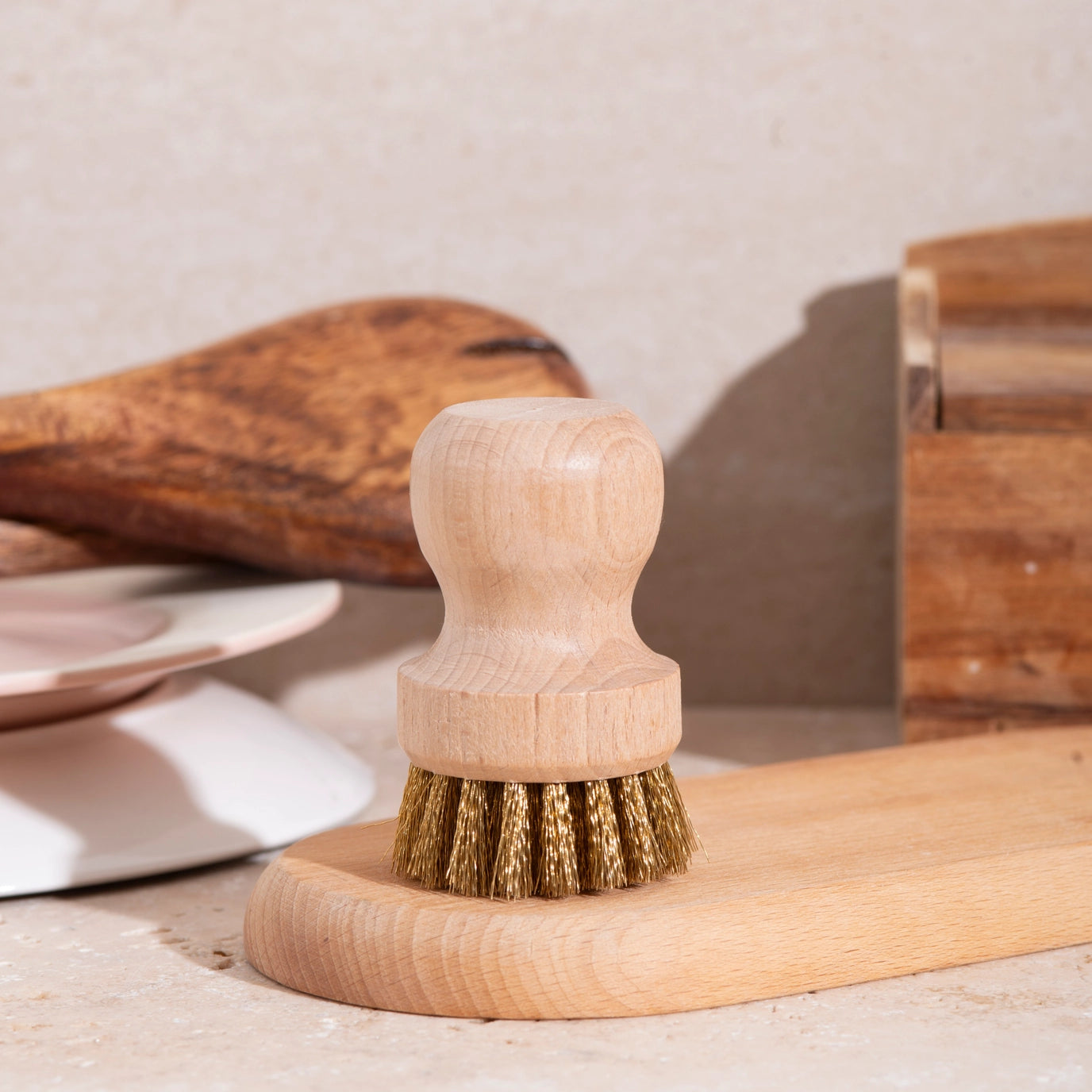 Wooden dish brush with bristle head on a beige surface