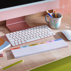 notepad in front of keyboard and computer