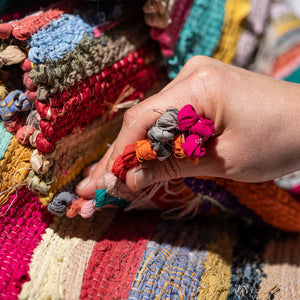 hand holding the colourful rug