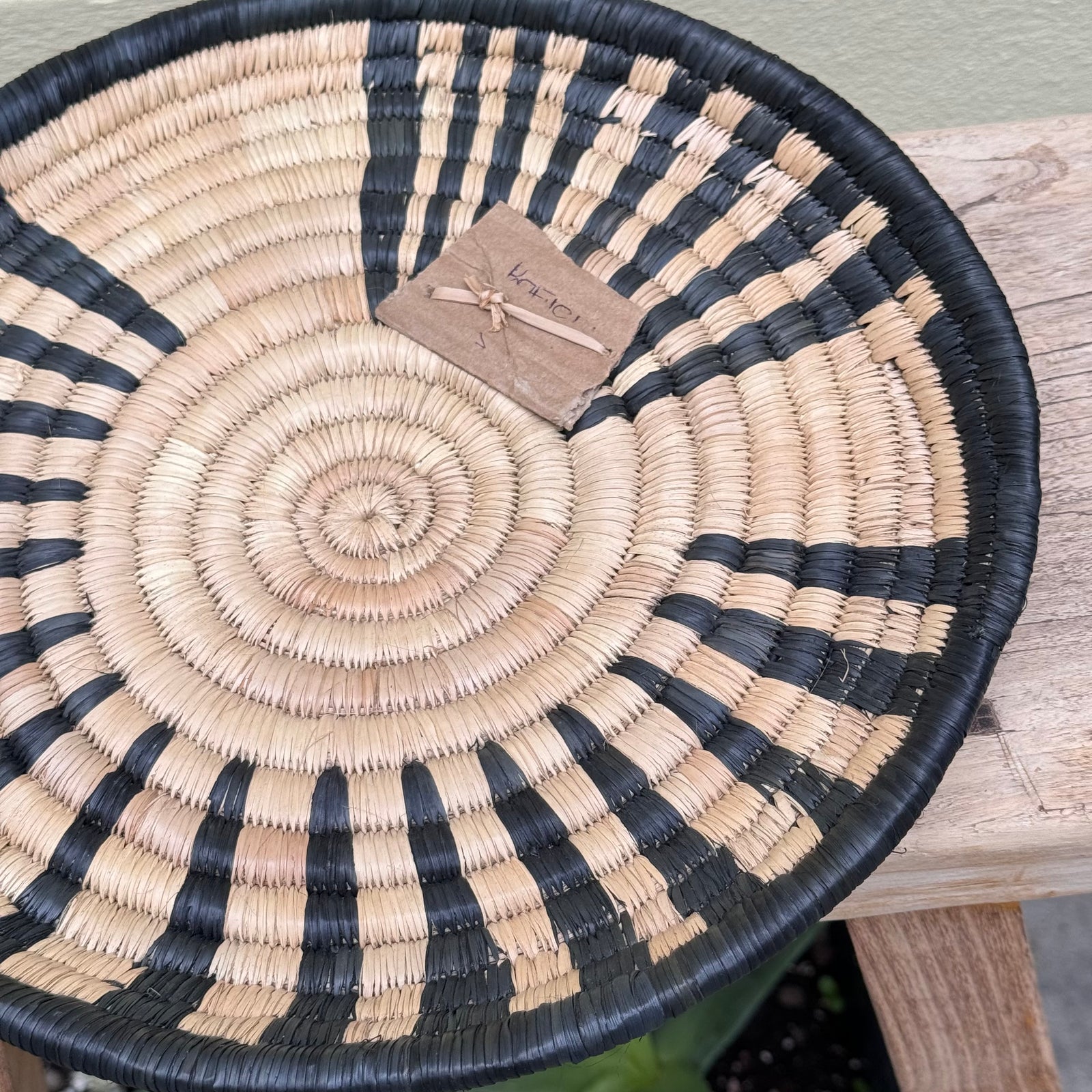 handwoven tray or wall decor in round with woven black pattern