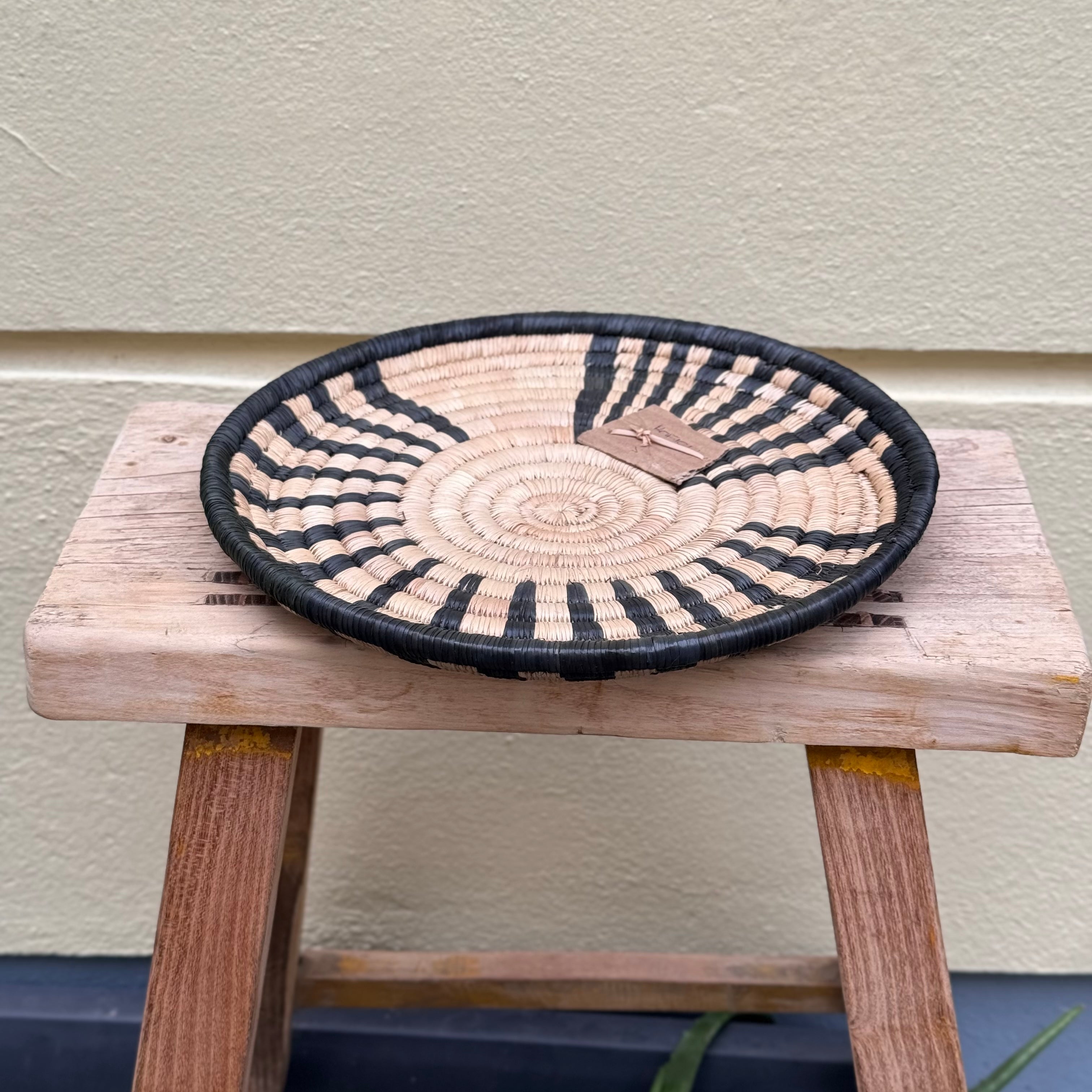 handwoven tray or wall decor in round with woven black pattern