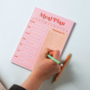 writing down shopping list on meal planner