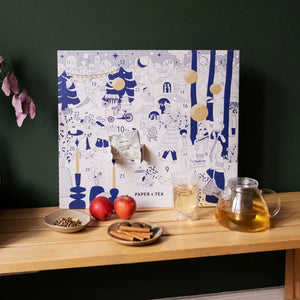 Tea-themed advent calendar on a wooden surface with tea accessories.