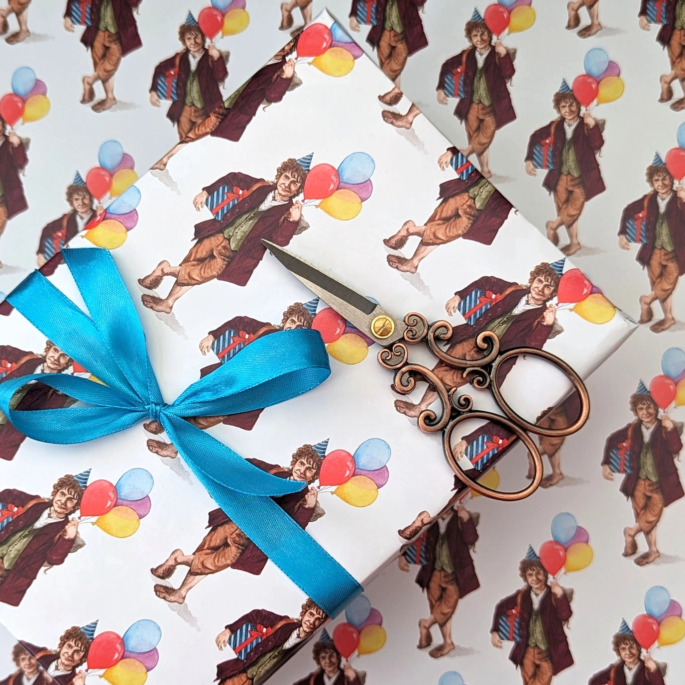 Gift wrapped with blue ribbon and scissors on a patterned background