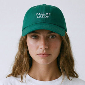 Person wearing a green cap with 'Call Me Daddy' text on a white background
