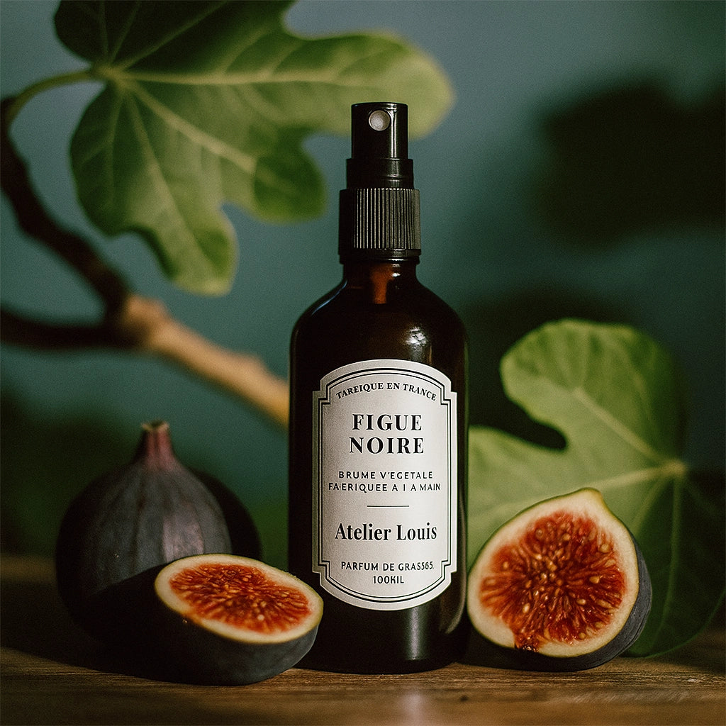 Bottle of 'Figue Noire' with a fig and leaf on a neutral background