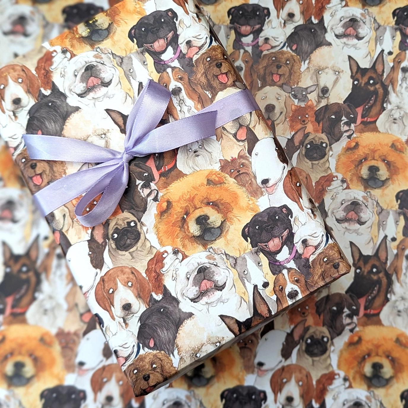 Gift box with dog pattern and purple ribbon surrounded by more dog images