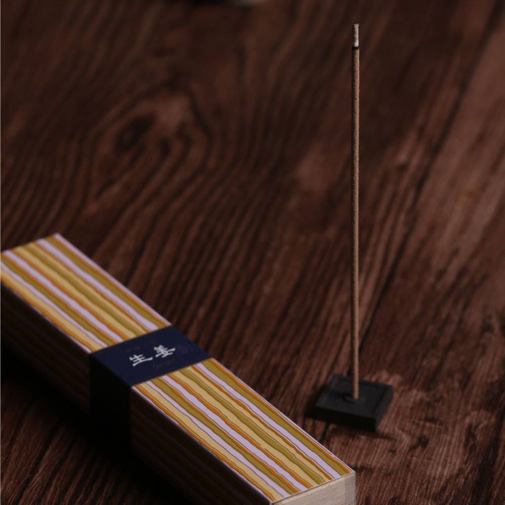 Incense sticks in a wooden box with striped packaging on a white background