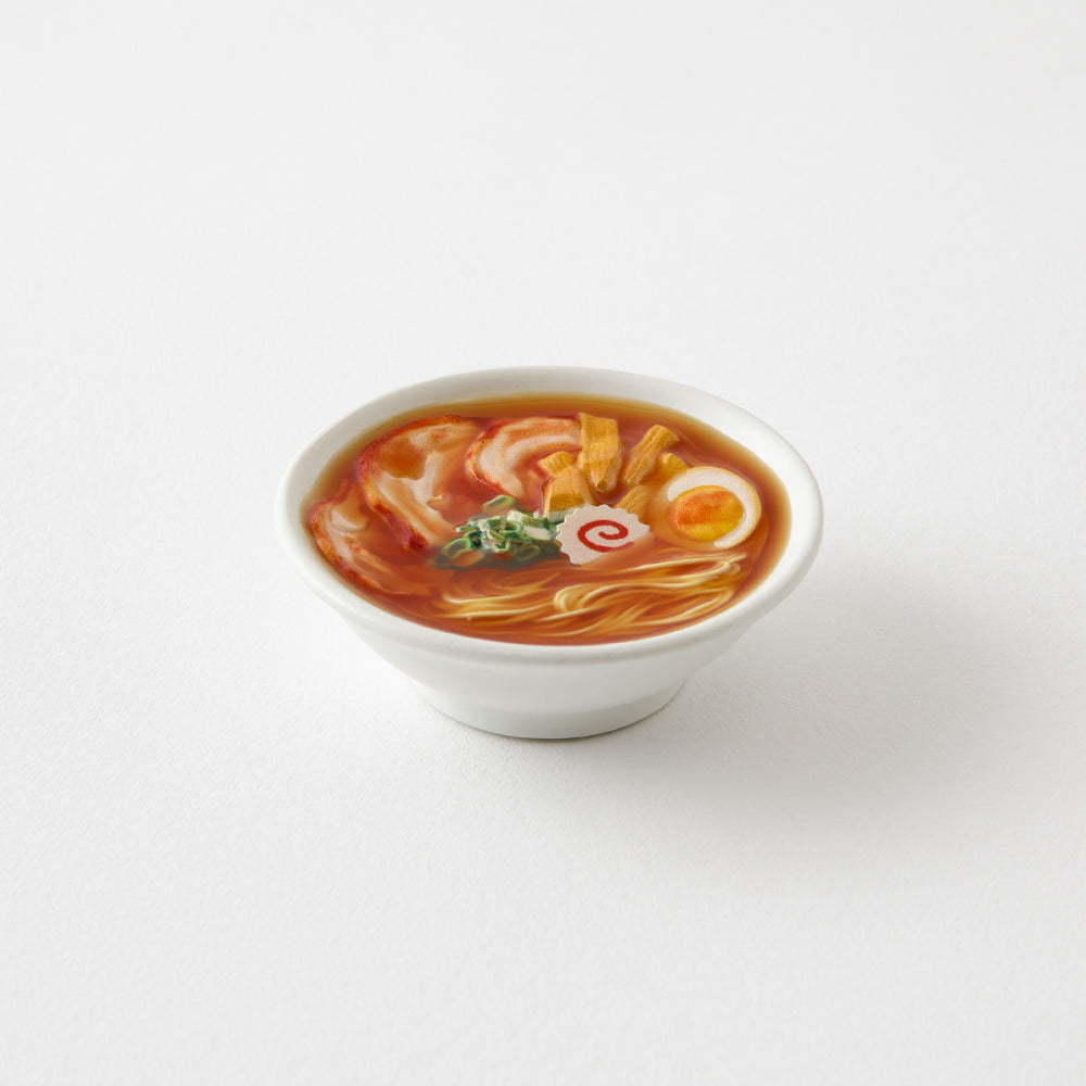 Packaged miniature ramen magnet with branding on a white background