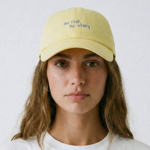 Person wearing a yellow cap with text on a white background
