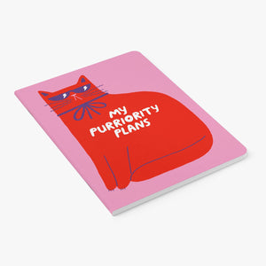 Notebook with a red cat illustration and text on a pink background