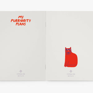 Open notebook with red text and cat illustration on white background