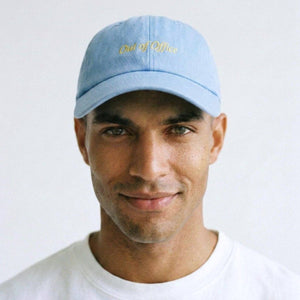 Man wearing a light blue cap with text on a white background