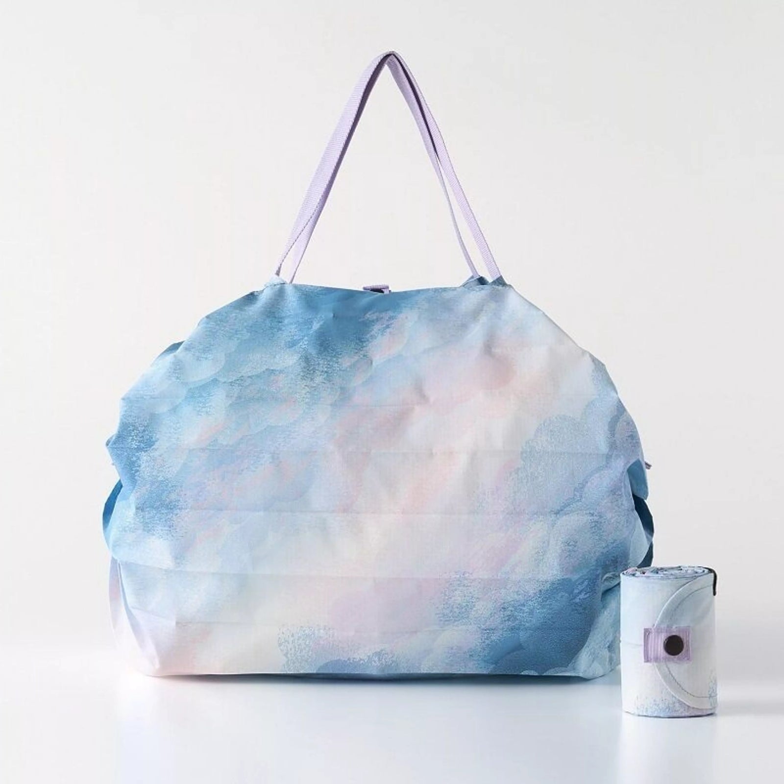 Person holding a blue patterned bag in a room with wooden furniture and a chair.