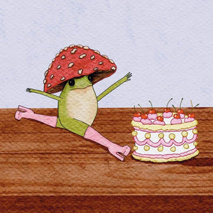 A whimsical watercolor-style illustration of a green frog wearing a red mushroom cap, stretching beside a decorated cake on a wooden surface against a pale blue background.