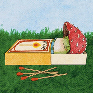 Matchbox with matches and a mushroom on grass with blue sky