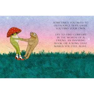 A square art print or card featuring a watercolor-style illustration of two dancing frogs on grass, with a red mushroom figure on the left and a motivational quote on the right against a pastel sky background.