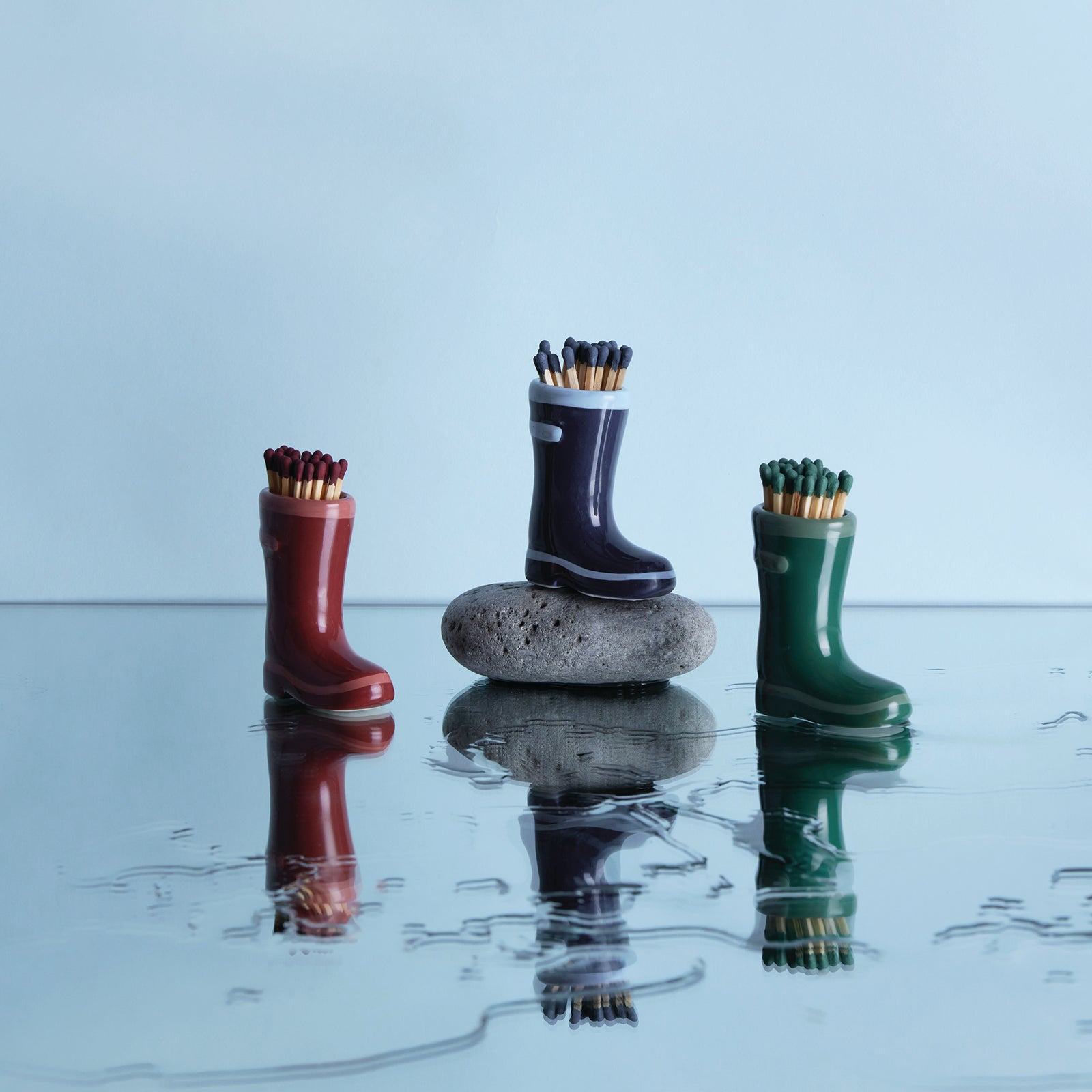 green ceramic wellington boots holding matches