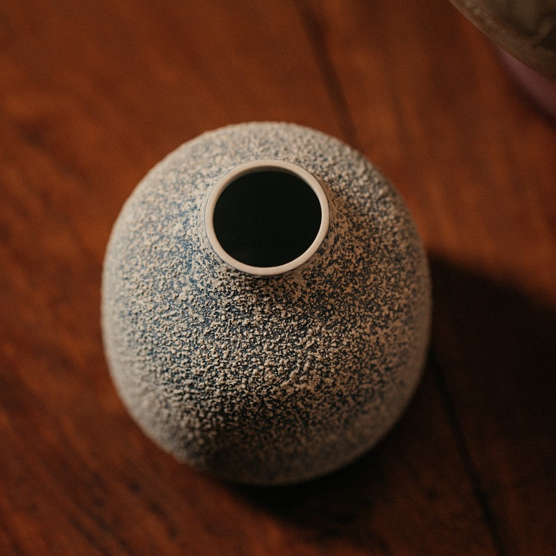 Blaue Vase mit strukturiertem weißen Spritzer