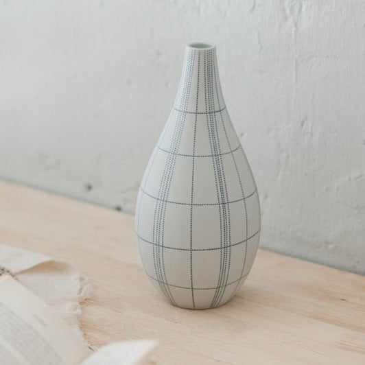 Weiße Flaschenvase mit blau gepunkteten Linien